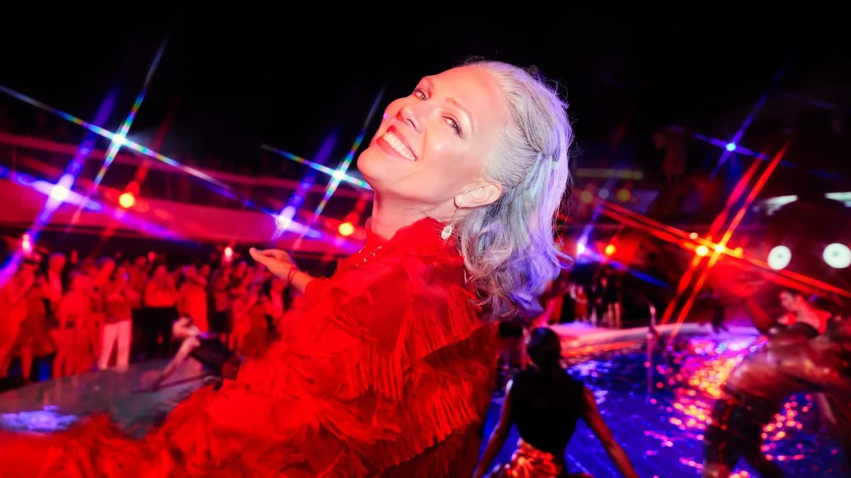 Sailors dressed in red dancing at the Scarlet Night pool-deck party on a Virgin Voyages cruise.